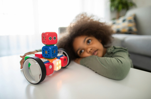 child playing with plastic robot on table