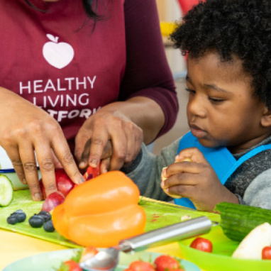 Young child cutting vegetables