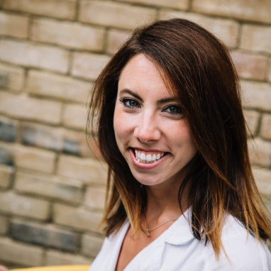 Woman with long brown hair smiling at camera
