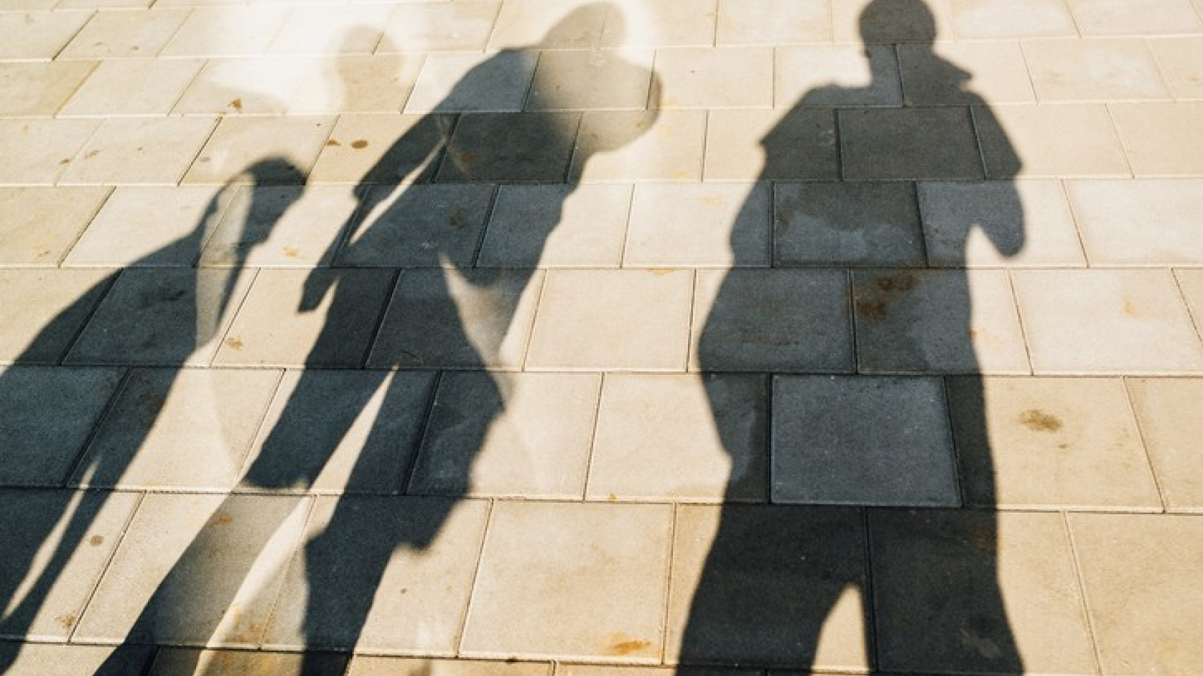 Shadows of people on pavement