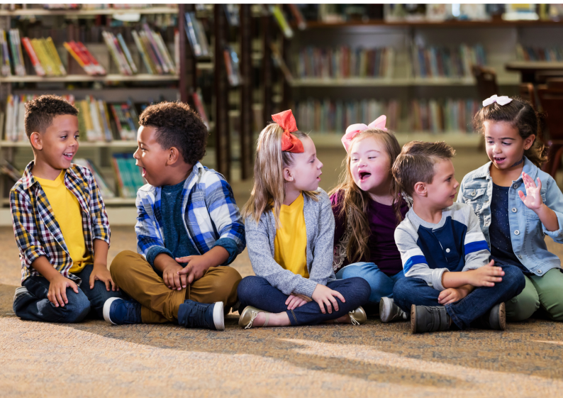 A group of young children sat on the floor in an education/childcare environment