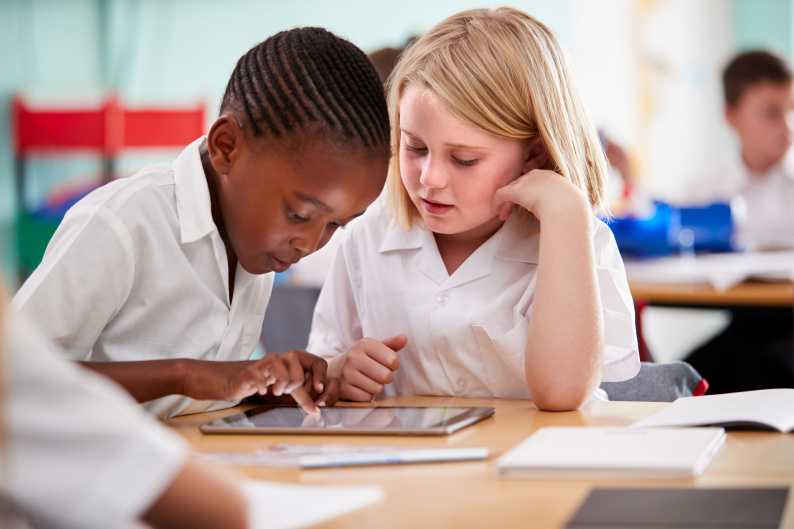 A schoolboy and schoolgirl collaborate on learning