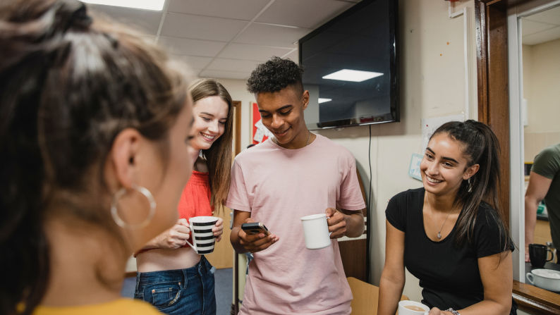 Four teenagers having a cup of tea