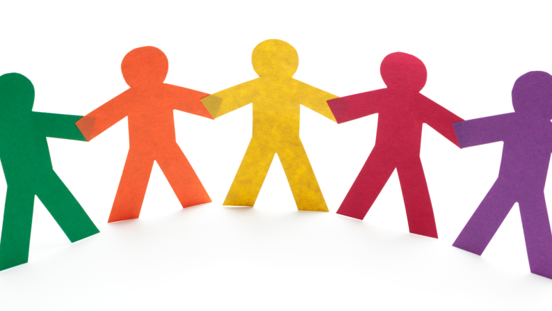 Paper cut outs of people in different colours holding hands