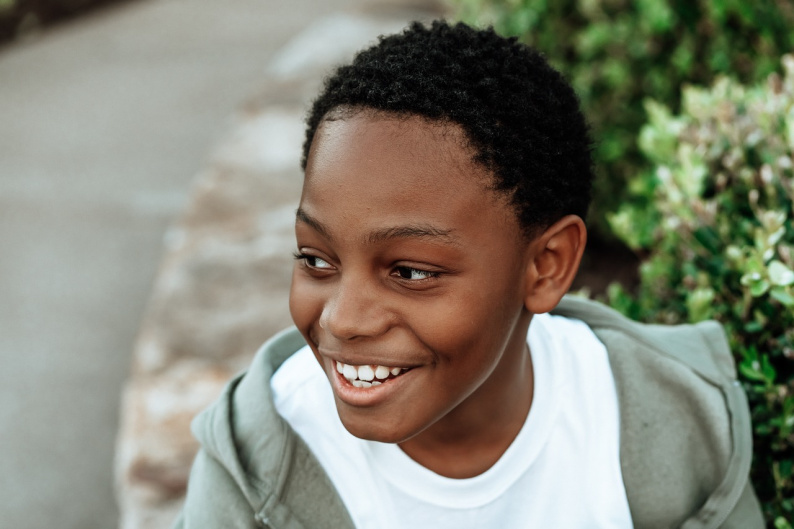 Child smiling looking away from camera